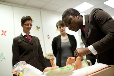 Yolande, élève gouvernante d'enfants à l'academie des gouvernantes change la couche d'un nourrisson © Julien Muguet